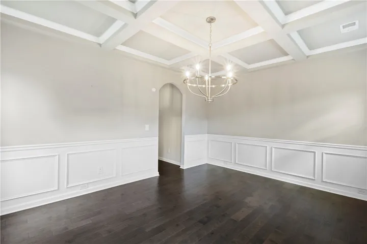 Elegant wainscoting and a classic coffered ceiling elevate this formal space.