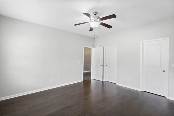 Rich dark wood flooring provides a striking contrast against crisp white trim and doors.