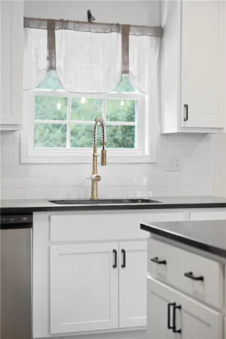 Granite countertops and clean white cabinetry anchor this sleek kitchen workspace.