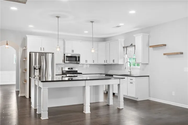 Polished hardwood flooring runs through this airy workspace complete with a central prep island.