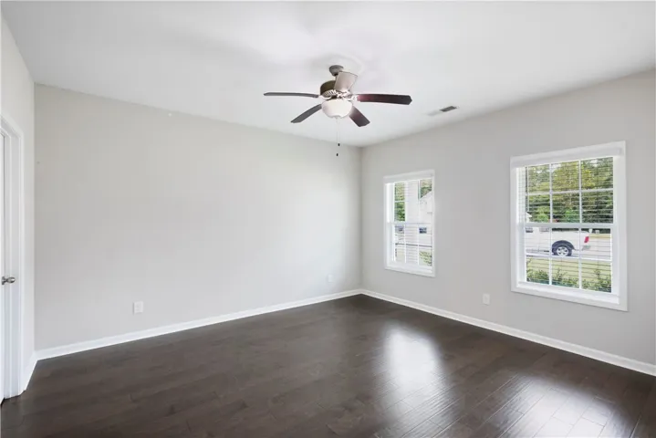 Rich dark wood floors anchor this versatile room illuminated by classic multi-pane windows.