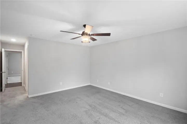 Plush wall-to-wall carpeting and clean neutral walls anchor this versatile secondary bedroom space.