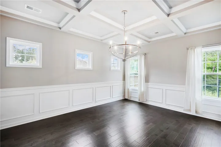 Elegant coffered ceilings and classic wainscoting define this refined, light-filled dining space.