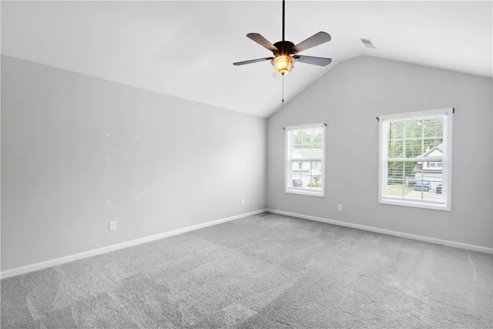 Vaulted ceilings and plush carpeting define this airy bedroom space.