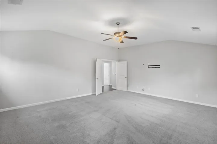 Vaulted ceilings and plush carpeting define this spacious main bedroom.