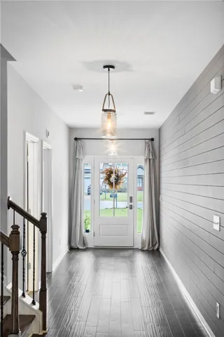Elegant shiplap walls and gleaming wood floors define this welcoming entry hallway.