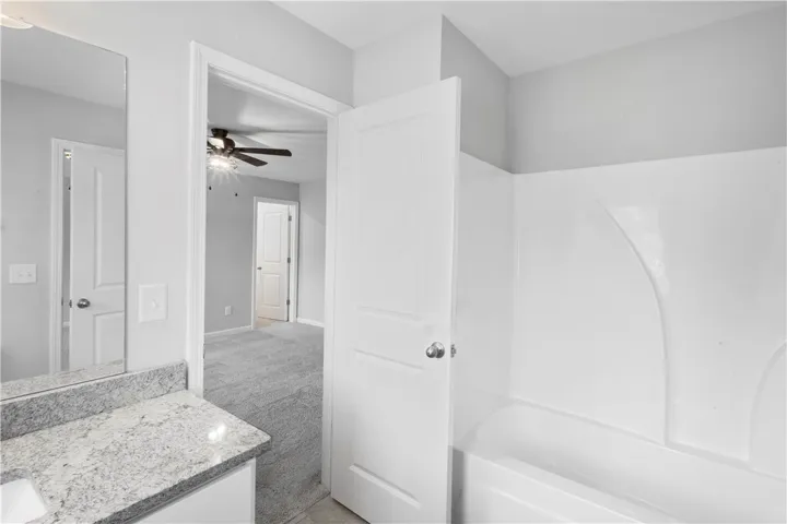 An en-suite bathroom connects seamlessly to a carpeted bedroom suite.