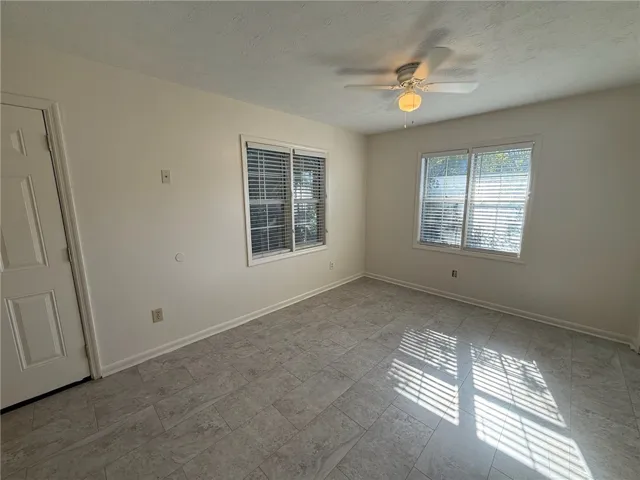 Durable tile flooring and classic wood-framed windows enhance this versatile room.