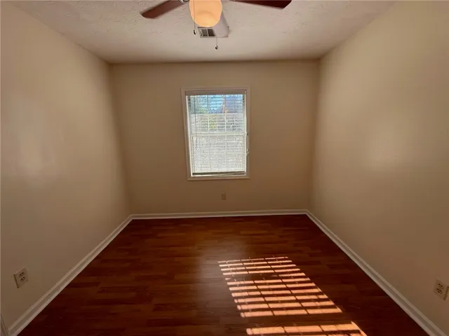 Rich wood floors lay a warm foundation below a window overlooking the outdoors.