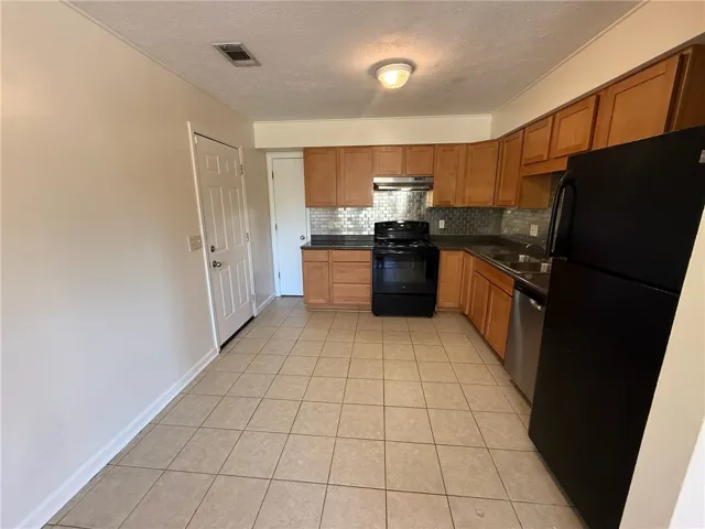 Functional kitchen design showcases classic wood cabinets and durable ceramic tile flooring.