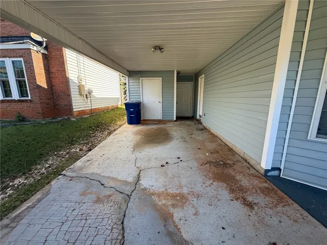 A covered carport provides sheltered parking adjacent to the home.