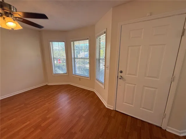 Warm wood flooring pairs with abundant natural light near the welcoming front entry.