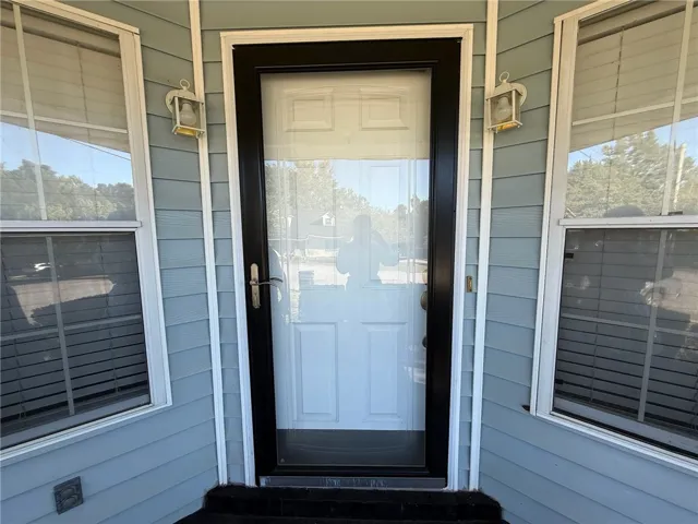 Welcoming front entryway features classic lap siding flanked by symmetrical windows.