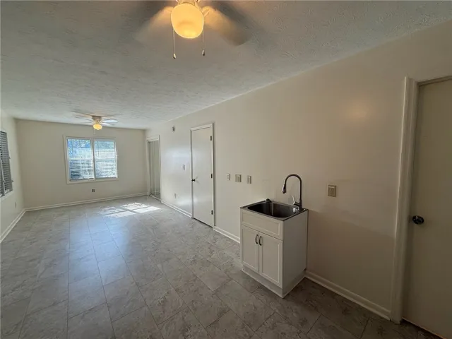 Durable tile floors flow through this versatile open space featuring a utility sink setup.
