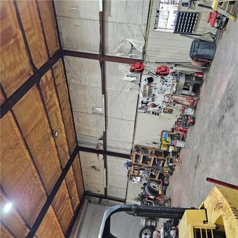 A spacious industrial workshop featuring concrete flooring and high ceilings with insulated panels.