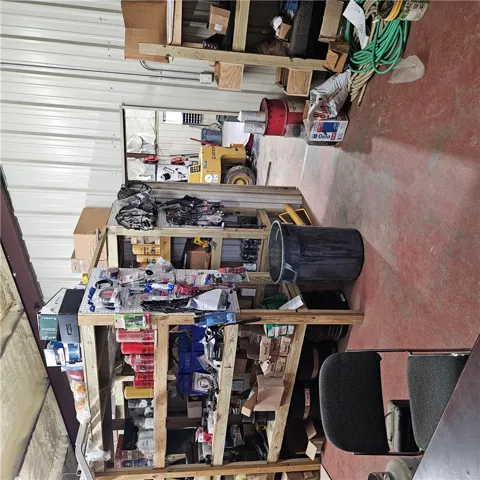 A spacious and practical workshop area features durable concrete flooring and high metal ceilings.