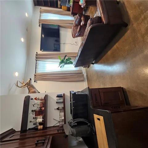 Stained concrete flooring anchors this open living space highlighted by recessed lighting and high ceilings.