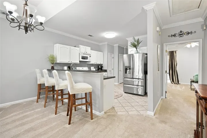 Crown molding highlights the transitions between soft-toned walls and comfortable carpeted flooring.