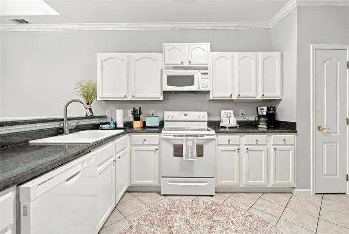 Granite countertops and classic cabinetry define this functional workspace with convenient breakfast bar seating.