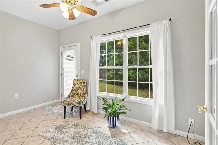 Large windows bring natural light and views of the garden into this tiled room.
