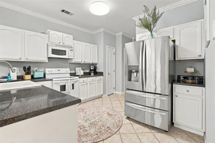 Polished stone countertops pair elegantly with classic raised-panel cabinetry and sleek stainless steel appliances.