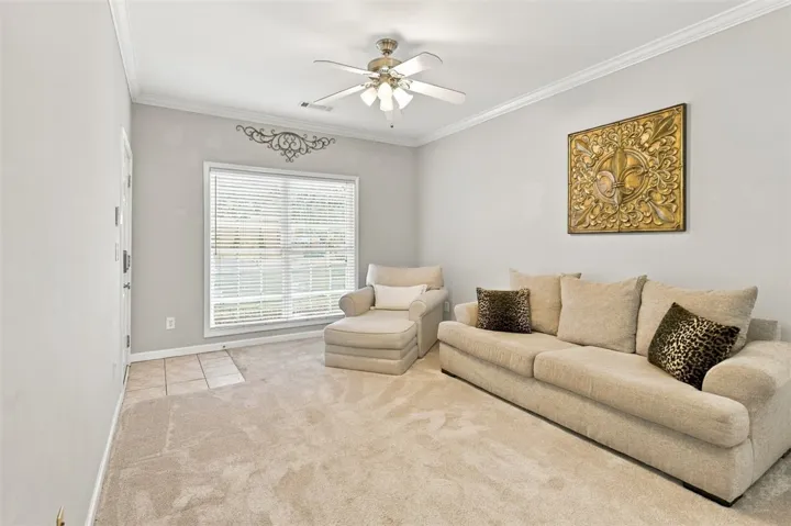 Crown molding and plush carpet frame this comfortable living space.