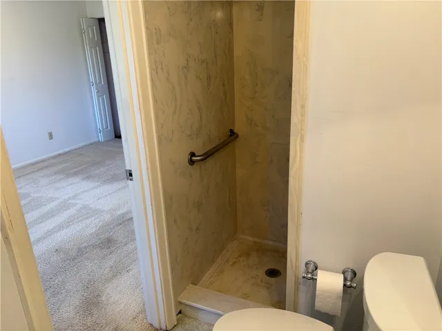 Primary bathroom layout features a walk-in shower equipped with a safety grab bar.