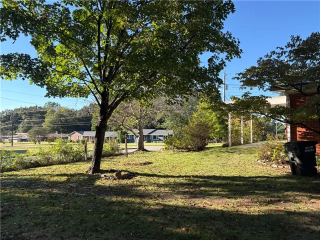 Mature trees shade the grassy lawn