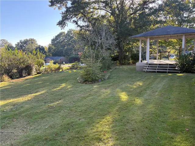Mature trees shade a spacious, grassy lawn