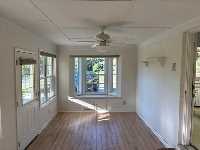 A bright bay window frame this welcoming sunroom space.