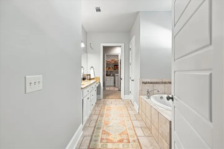 Tiled flooring and a built-in soaking tub anchor this spacious layout.