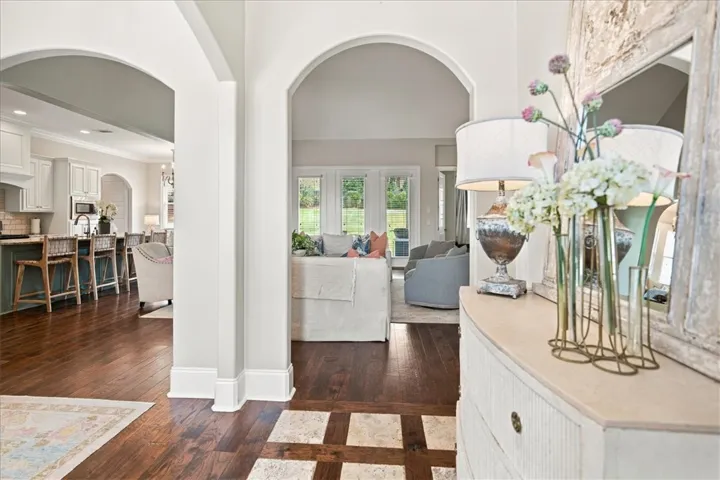 Arched doorways frame views of the open layout and rich hardwood flooring.