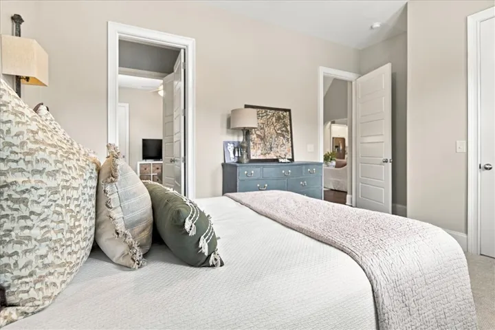 A tranquil sleeping space connects seamlessly to adjacent rooms through classic paneled doors.