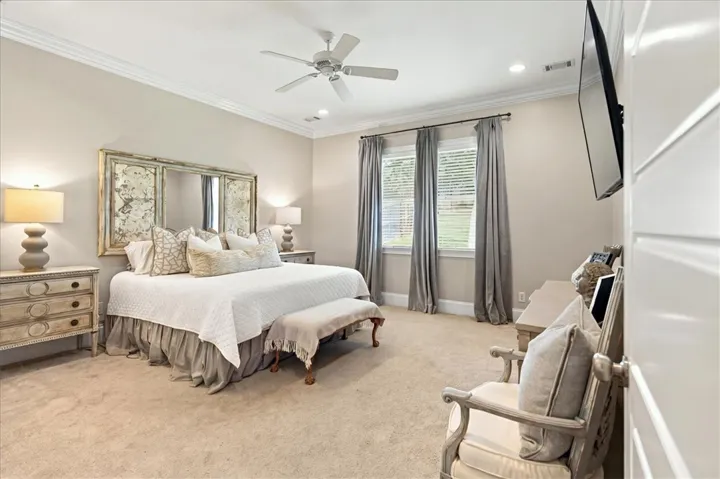 Plush carpeting and classic crown molding elevate this relaxing primary suite sanctuary.