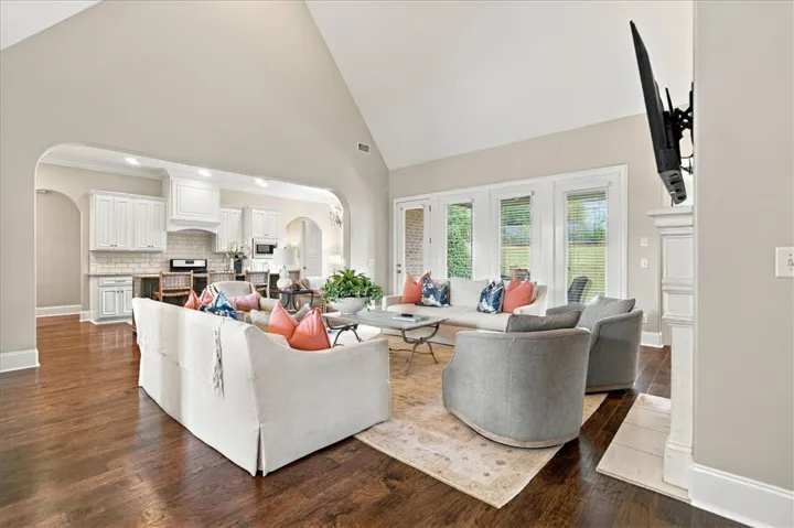 A soaring vaulted ceiling and rich hardwood floors define this open main-level living space.