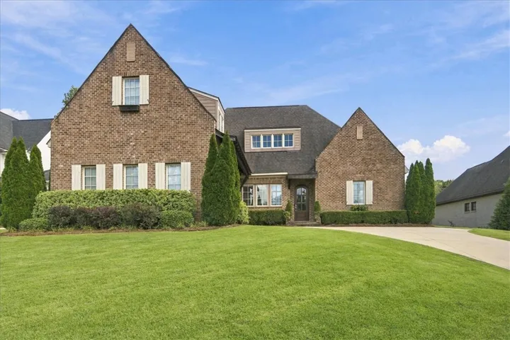 Timeless brick architecture defines this stately home set against a manicured green lawn.