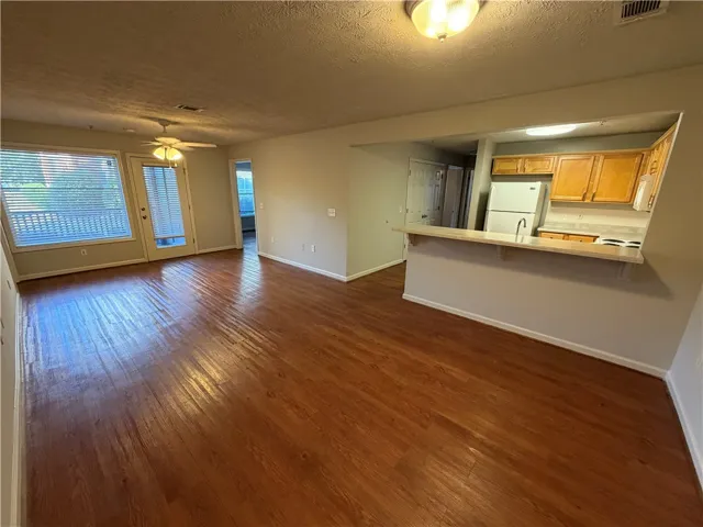 Gleaming hardwood floors and a raised breakfast bar define this versatile open living space.