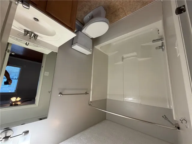 Functional layout maximizes utility with a shower and tub combination alongside a classic vanity.