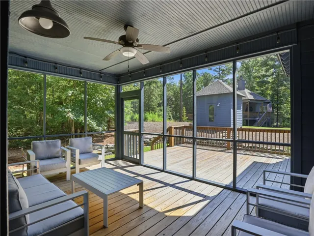 An inviting screened porch features beadboard ceilings and wood flooring overlooking the deck.