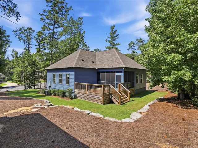 A spacious wooden deck and screened porch extend from the rear of the home.