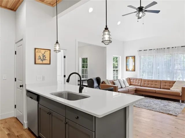 An open floorplan seamlessly connects the island kitchen with the adjacent living space.