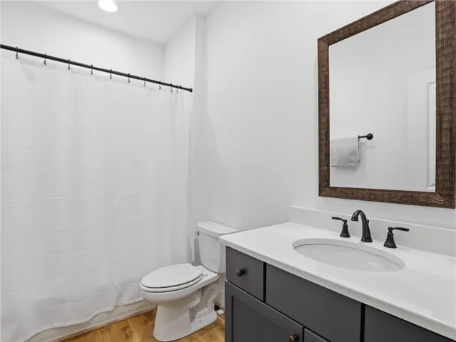 Clean lines and warm wood flooring define this updated guest bathroom.