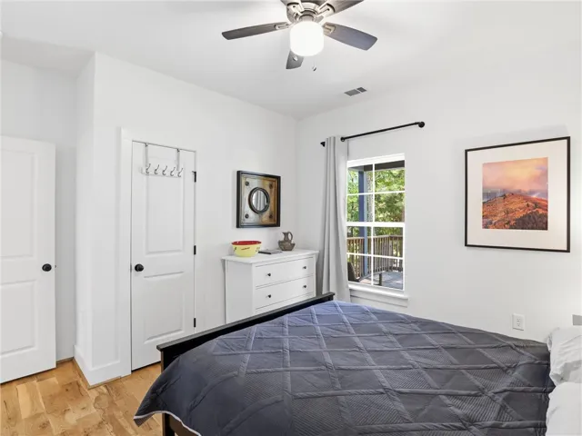 Rich hardwood flooring anchors this inviting bedroom containing a window overlooking the private deck.