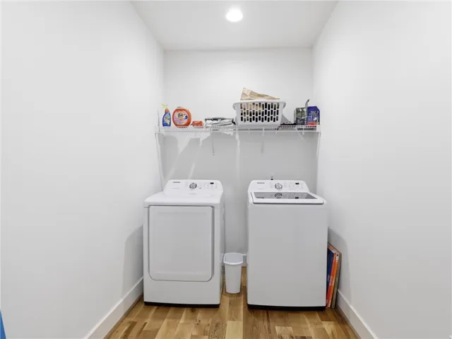 Hardwood floors and overhead recessed lighting bring style and functionality to this dedicated laundry alcove.