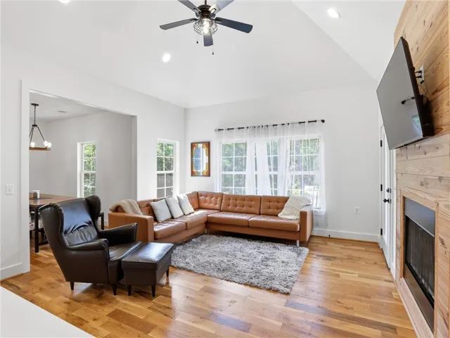 Gleaming hardwood floors and a warm wood-clad fireplace create an inviting interior atmosphere.