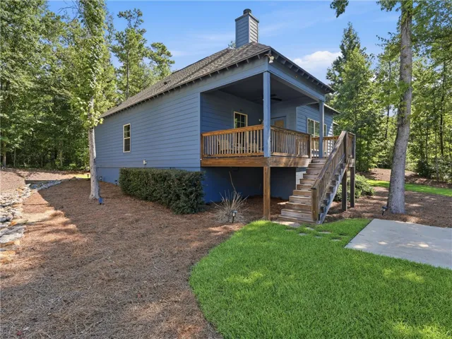 An elevated wooden deck extends from the back of this wooded retreat.