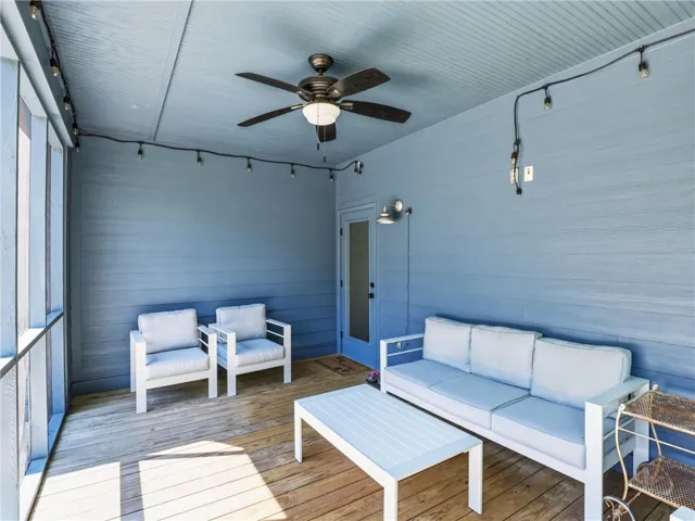 Wood plank flooring and horizontal siding define this welcoming screened porch space.
