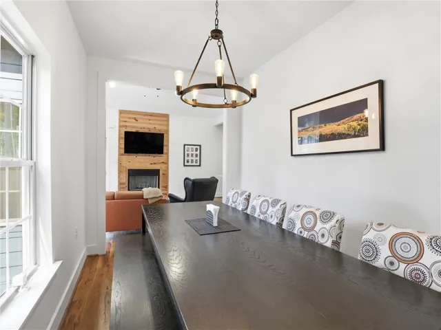 Rich hardwood floors and a modern ring chandelier enhance this inviting dining room.