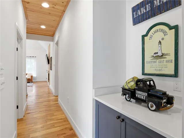 Warm wood flooring and planked ceilings guide visitors through this welcoming entryway hall.