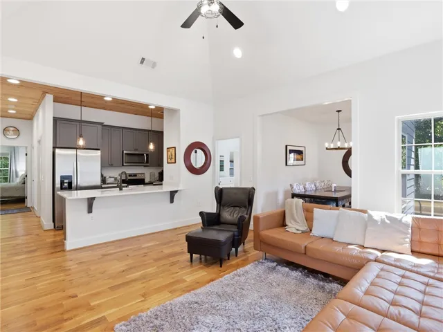 An open floor plan connects the living room to the kitchen under vaulted ceilings.